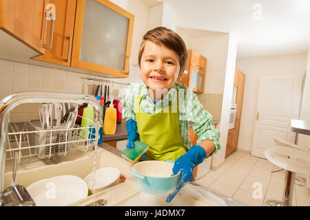 Süßes Kind Junge den Abwasch in Gummihandschuhe Stockfoto