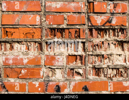 Ein Fragment einer Wand aus einem alten roten teilweise zerstörten Lehmziegel Stockfoto