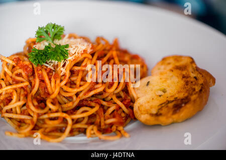 Spaghetti Bolognese mit einem Stück Zwieback mit Knoblauch auf einem Teller hautnah Stockfoto