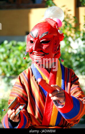 Atsara (Joker) tragen rote traditionelle bhutanische Kleid unterhaltsame Menschen im Mask Dance Festival in Bhutan Stockfoto