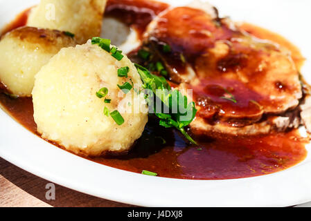 Traditionelle deutsche bayerischen Schweinebraten mit Sauce und Kartoffel-Knödel Stockfoto