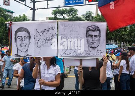 Zwei Frauen tragen Zeichnungen über Juan Pablo Pernalete und Armando Cañizales, junge Menschen, die kürzlich an den Protesten von feuert Tränengas direkt an seinem Körper, von der Polizei und Nationalgarde getötet. Schlamm (Bureau of Unity) marschiert zusammen mit Tausenden der Venezolaner gegen die verfassungsgebende Versammlung in Caracas. Mai, 8.2017 Stockfoto