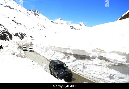 Srinagar, Kaschmir. 12. Mai 2017. Fahrzeuge fahren durch Schneewände am Zojila-Pass. Srinagar-Leh Straßenverbindung wurde aufgestoßen für Fahrzeugverkehr nach rund fünf Monate lang durch Schnee blockiert. Die 434 Kilometer lange Straße wurde nach starkem Schneefall im Dezember 2016 geschlossen. Die Border Roads Organisation (BRO), unterhält die Straße öffnete sie nach Schneeräumung von Zojila Pass, 3.630 Meter über dem Meeresspiegel. Bildnachweis: Sofi Suhail/Alamy Live-Nachrichten Stockfoto