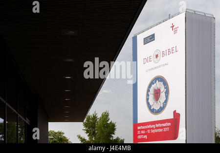 Eine überdimensionale Bibel, übersetzt von Martin Luther (1483-1546), Darstellung einer Luther-rose und eine Werbung für die "Welt Ausstellung Reformation 20. Mai - 10. September" am Hauptbahnhof in Lutherstadt Wittenberg, Deutschland, 12. Mai 2017 zu sehen. Foto: Peter Endig/Dpa-Zentralbild/ZB Stockfoto