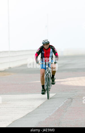 Denbighshire, Wales, UK Wetter-Kühler mit der Wahrscheinlichkeit von schweren Regen heute in Nord Wales und für das Wochenende. Ein wenig morgen Fitness für diese Radfahrer entlang der Strandpromenade in Rhyl in Nord Wales Stockfoto