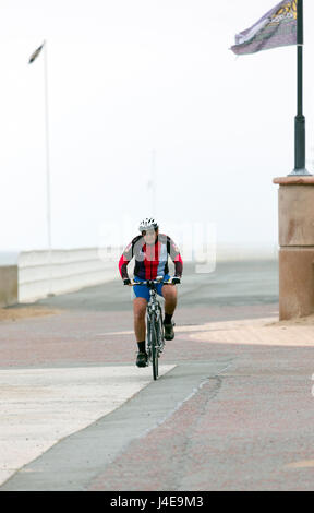 Denbighshire, Wales, UK Wetter-Kühler mit der Wahrscheinlichkeit von schweren Regen heute in Nord Wales und für das Wochenende. Ein wenig morgen Fitness für diese Radfahrer entlang der Strandpromenade in Rhyl in Nord Wales Stockfoto