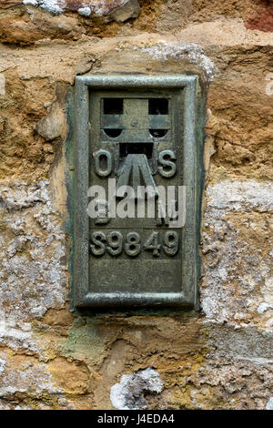 Ordnance Survey Benchmark auf eine Kirchenmauer, Northamptonshire, UK Stockfoto