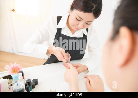 Schönheit-Nahaufnahme von Frau Hände Behandlung Körper Pflege durch professionelle Maniküre Spezialist im Salon. die Hände Maniküre Nagelhaut schneiden auf Nägel wi Stockfoto