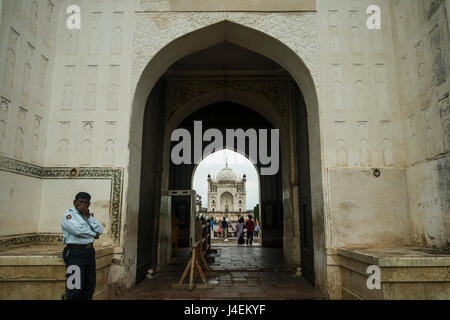 Ein Wachmann als durch den Eingang Bögen sehen wir die Bibi Ka Maqbara, einem strengen Denkmal. Stockfoto