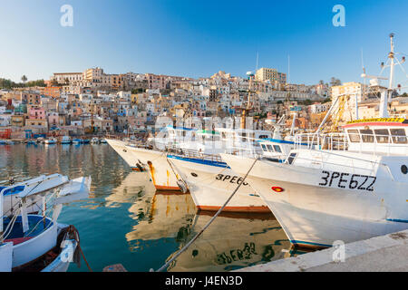 Angelboote/Fischerboote vertäut im Hafen umgeben von blauem Meer und der Altstadt entfernt, Sciacca, Provinz Agrigento, Sizilien, Italien Stockfoto