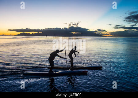 Stehen Sie Paddler im Sonnenuntergang mit Moorea im Hintergrund, Papeete, Tahiti, Gesellschaftsinseln, Französisch-Polynesien auf Stockfoto