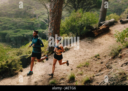 Junges Paar auf Land Trail ausgeführt. Junger Mann und Frau läuft durch Bergpfad. Stockfoto