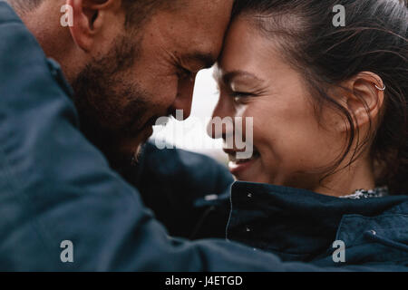 Close-up Seite Porträt des jungen Mischlinge paar in der Liebe. Romantisches Paar umarmen einander und lächelnd. Stockfoto