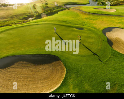 Luftbild von Spielern auf einem grünen Golfplatz. Golfer spielen auf Putting Green an einem Sommertag. Stockfoto