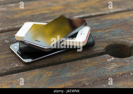 Ein Stapel von Smart Phones außerhalb auf einem pub Tabelle. Stockfoto