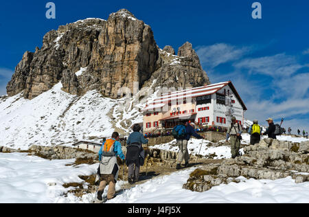 Wanderer auf dem Weg zur Dreizinnenhütte, Rifugio Locatelli Hütte, schneebedeckte Gipfel Sextener Stein, Sasso di Sesto und Turm Toblin Torre di Tobli Stockfoto