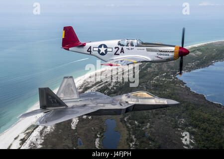 Air Force F-22 Raptor fliegen in Formation mit einem Zweiten Weltkrieg P-51 Mustang Stockfoto