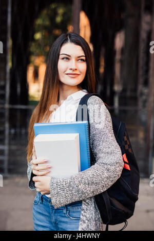 Student mit Notebooks und Tasche vor University College Stockfoto
