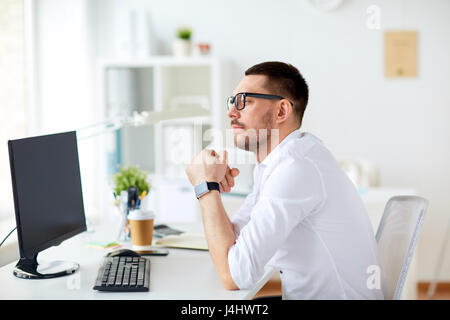 Geschäftsmann in Gläsern sitzen am Computer im Büro Stockfoto