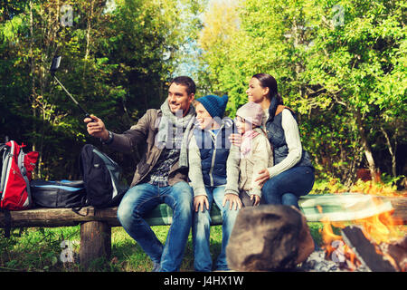 Familie mit Smartphone unter Selfie nahe am Lagerfeuer Stockfoto