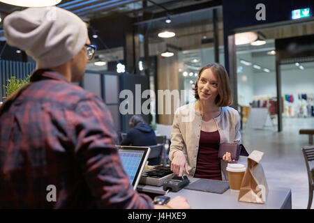 glückliche Frau Einkäufe im Café bezahlen Stockfoto