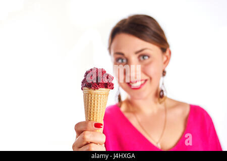 Lächelnde Frau trägt eine rosa Bluse, und Eis Waffelhörnchen Blick in die Kamera hält. Isoliert auf weiss. Stockfoto