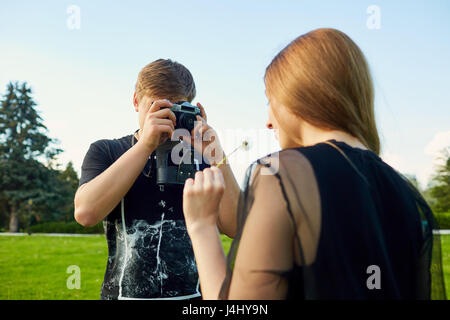 Ein Fotograf fotografiere Mädchen vor der Kamera im park Stockfoto