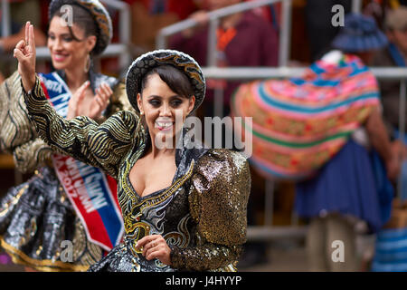 Caporales Tänzerin in kunstvollen Kostümen, die Durchführung, wie sie durch die Bergbau-Stadt Oruro auf dem Altiplano von Bolivien während der jährliche Karneval parade. Stockfoto