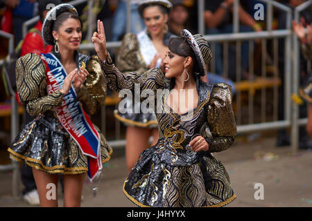 Caporales Tänzerin in kunstvollen Kostümen, die Durchführung, wie sie durch die Bergbau-Stadt Oruro auf dem Altiplano von Bolivien während der jährliche Karneval parade. Stockfoto