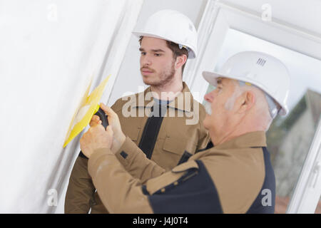 Lehrling gerade Lehrer mit Kelle auf Wand Stockfoto