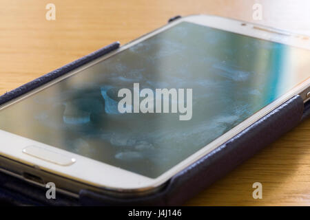 A closeup on a smartscreen screen showing smears and fingerprints Stockfoto