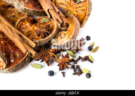 Aromatisch und wärmenden getrocknete Ayurveda Gewürze (Zimt, Bael Frucht, Sternanis, Wacholderbeeren, Kardamom, Nelken) auf weißem Hintergrund Stockfoto