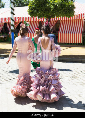 Sevilla, Provinz Sevilla, Andalusien, Südspanien.  Feria de Abril, April Fair.  Junge Frauen Flamenco-Kleider tragen. Stockfoto