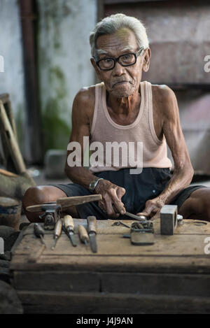 Senior-Zimmermann bei der Arbeit in seiner Werkstatt in Yogyakarta, Java, Indonesien. Stockfoto