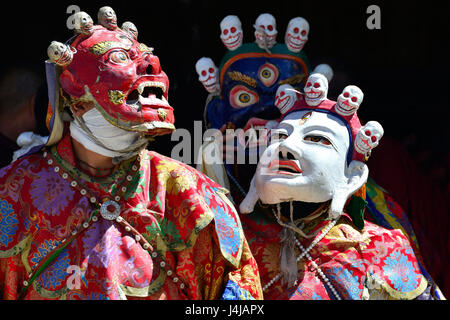 Buddhistische Geheimnis mit der Leistung der Cham-Tanz im tibetischen Kloster in Zanskar: rot, weiß und blau Masken mit Totenköpfen, leuchtend roten Roben von Mo Stockfoto