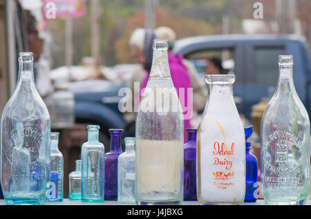 Nahaufnahme des alten farbigen Glasflaschen an einem externen Antiquitätengeschäft. Stockfoto
