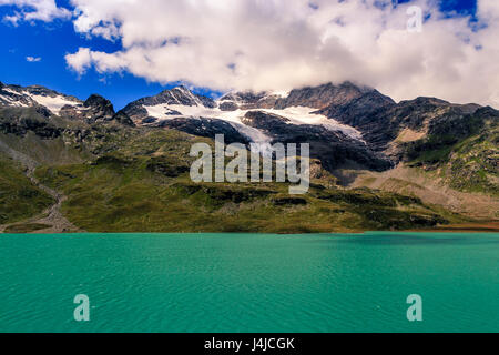 Lago Bianco und die Berge von der Bernina bei Ospizio Bernina unter weißen Wolken im Sommer. Dies ist der höchste Punkt auf der Bernina Railw Stockfoto