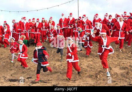 Perranporth, Cornwall, UK. 18. Dezember 2016. Santa auf dem Sand eine jährliche Charity laufen am Strand von Perranporth in Cornwall, Großbritannien Stockfoto