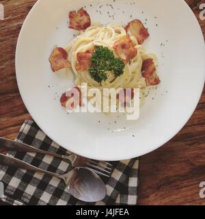 Spaghetti Carbonara mit Speck auf Holztisch Stockfoto