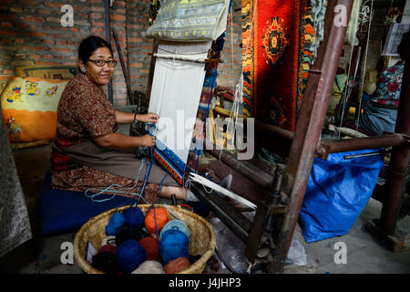 NEPAL Kathmandu, Lalitpur, tibetisches Flüchtlingslager Jawalakhel, Teppichfabrik JHC Jawalakhel Handicraft Center, tibetische Flüchtlingsfrauen Knoten Teppiche am Webstuhl für Einkommenserzeugung Stockfoto