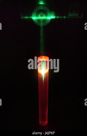 Laser und Rubin-Stab. Experimentieren Sie mit einem grünen Laserstrahl wird verwendet, um rote Lumineszenz in einem Stab von künstlichen Ruby zu induzieren. Synthetischer Rubin dient zur Rubin-Laser, wo grüne Laserlicht absorbiert und wieder als rote Laserlicht emittiert. Stockfoto