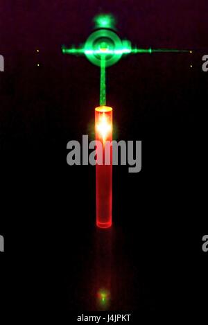 Laser und Rubin-Stab. Experimentieren Sie mit einem grünen Laserstrahl wird verwendet, um rote Lumineszenz in einem Stab von künstlichen Ruby zu induzieren. Synthetischer Rubin dient zur Rubin-Laser, wo grüne Laserlicht absorbiert und wieder als rote Laserlicht emittiert. Stockfoto