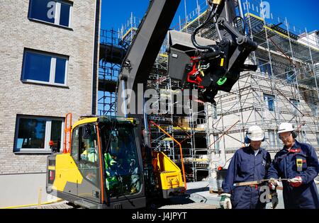 Bauarbeiter auf der Baustelle mit Bagger. Stockfoto