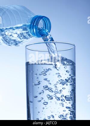 Gießt Wasser aus einer Plastikflasche in ein Glas, Studio gedreht. Stockfoto