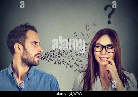 Sprache-Barriere-Konzept. Gutaussehenden Mann im Gespräch mit einer attraktiven jungen Frau mit Fragezeichen Stockfoto