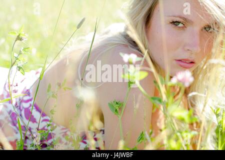 Junge Frau lag in der Wiese mit Wildblumen. Stockfoto
