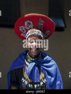 Südafrika, Lesedi, Zulu Frau, Kleidung, Kopfbedeckungen, traditionell, Porträt Afrika, nahe Johannesburg, Stamm, Zulu, Zulu Stamm, einheimischen, nicht-weißen, afrikanisch, Kopfschmuck, rot, Perlen Schmuck, Schmuck, Kap blau, Tradition, Folklore, Lächeln, glücklich Stockfoto