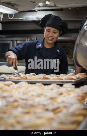 161002-N-BR087-001 Pazifik (2. Oktober 2016) Petty Officer 1st Class Esmeralda Bajit, von Mililani, Hawaii, bereitet Zimtschnecken Brunch in USS John C. Stennis' (CVN-74) Backstube. John C. Stennis ist im Gange Kompetenz und Durchhaltefähigkeit Training durchführen. (Foto: U.S. Navy Seemann Cole C. Pielop / veröffentlicht) Stockfoto