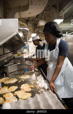 161002-N-BR087-096 Pazifik (2. Oktober 2016) Petty Officer 2. Klasse Selima Rougier, aus Brooklyn, New York, Pommes frites Eiern zum Brunch in USS John C. Stennis (CVN-74) achtern Galeere. John C. Stennis ist im Gange Kompetenz und Durchhaltefähigkeit Training durchführen. (Foto: U.S. Navy Seemann Cole C. Pielop / veröffentlicht) Stockfoto