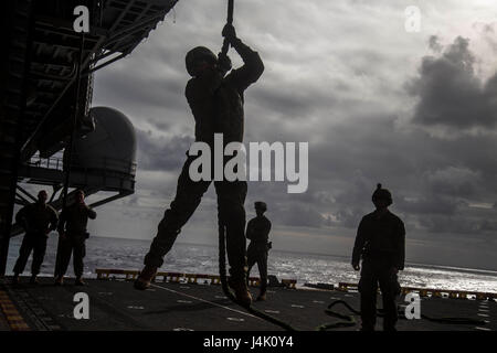 USS MAKIN ISLAND, auf hoher See (8. November 2016) – A Marine Battalion Landing Team 1. BN, 4. marinen 11. Marine Expeditionary Unit, gleitet hinunter ein Seil auf dem Hangardeck der USS Makin Insel (LHD 8), während der Hubschrauber Seil Aussetzung (HRST) Techniktraining durchgeführt während flott in den Pazifischen Ozean, 8. November 2016. Einer der wichtigsten taktischen Vorteile der HRST ist es erlaubt Marines einzufügende auf ein Ziel mit einem undurchdringlichen Terrain nicht freizügig für ein Flugzeug zu landen. Die 11. MEU, Teil der Makin Island amphibische bereit-Gruppe, ist in den USA operierende 7. Flotte Bereich Respon Stockfoto